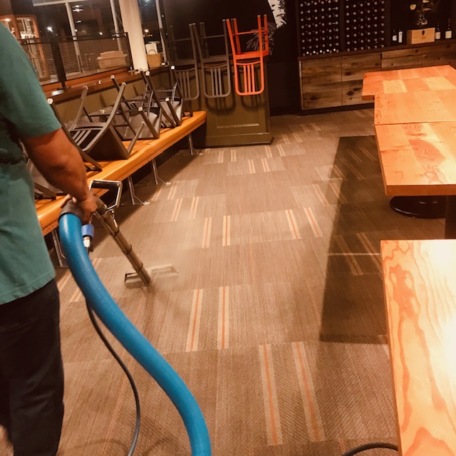 Man uses carpet extraction to clean commercial carpet.