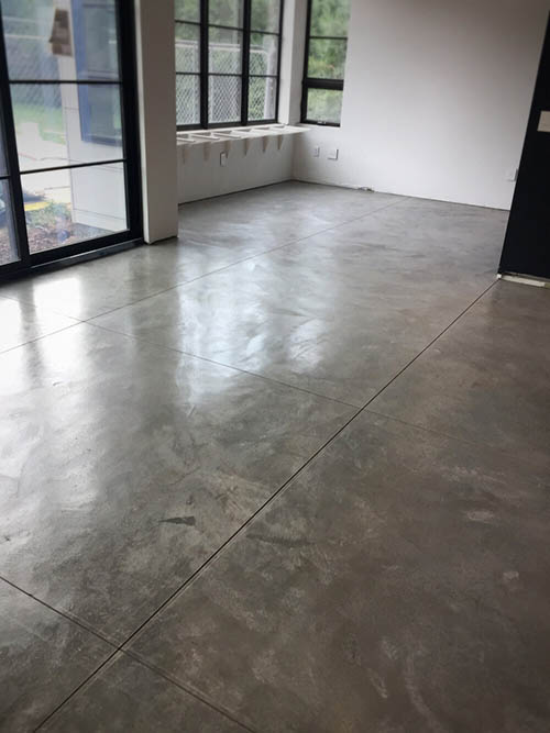 A cleaned and sealed exposed concrete floor with a satin finish.