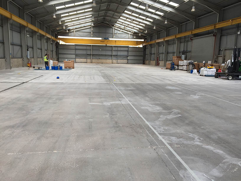 A dirty, industrial warehouse floor.  Concrete that has been beat up with heavy use.