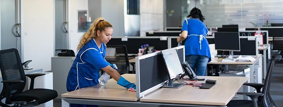 Female janitors clean a commercial office space.