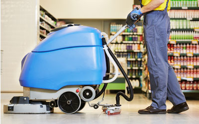 Floor scrubbing machine cleaning a commercial floor