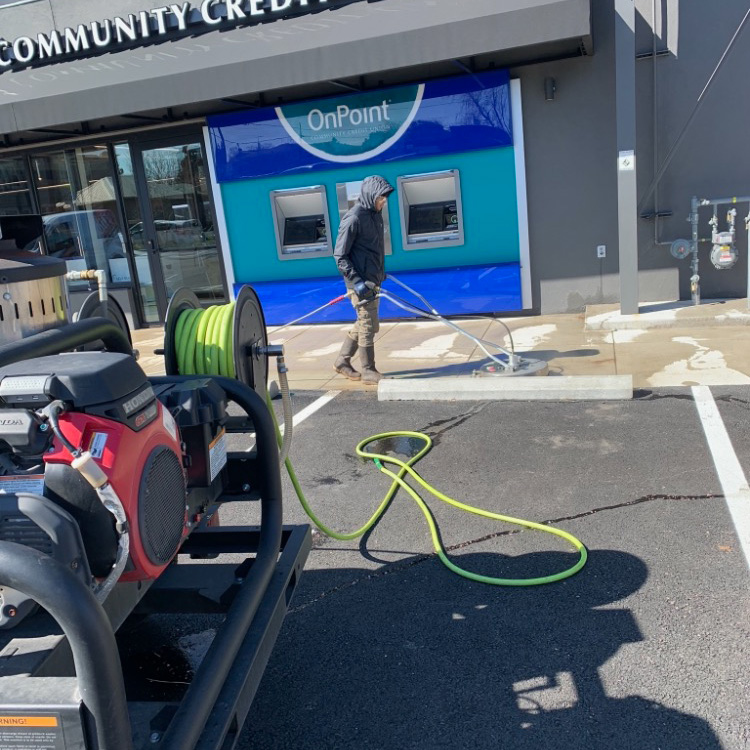 Pressure washing a storefront.